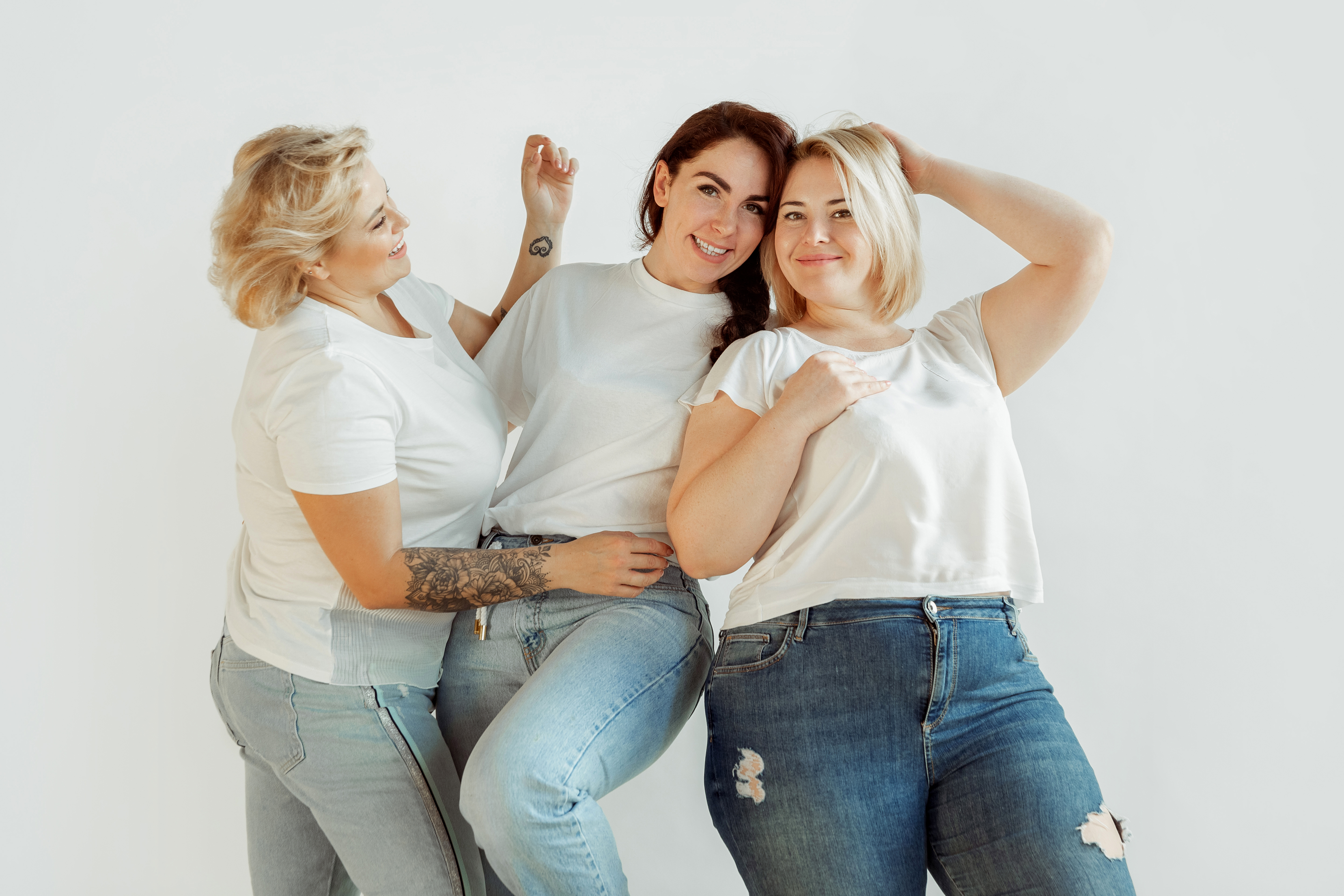 Confidence. Young caucasian women in casual clothes having fun together. Friends posing on white background, laughting, looks happy, well-kept. Bodypositive, feminism, loving themself, beauty concept.